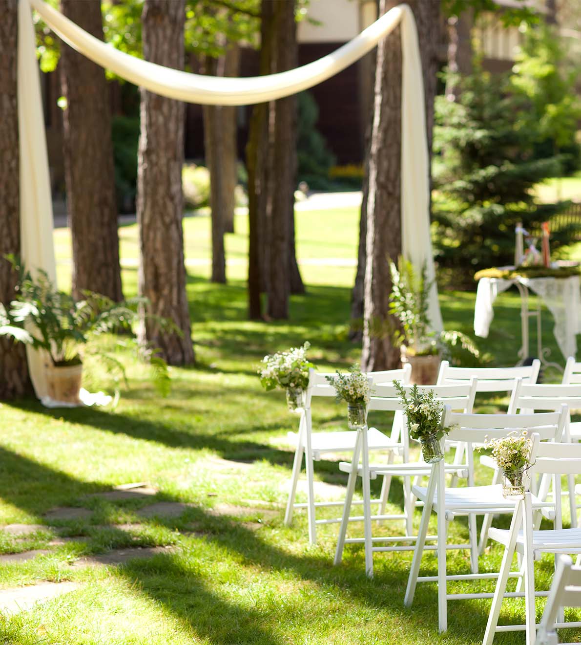 Image of arranged chairs in a park setting for an outdoor wedding